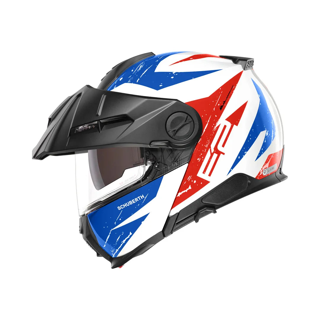 Schuberth E2 Explorer MC-hjälm i blå och röd design, visir nedfällt, sidovy med aerodynamisk form och robust konstruktion.